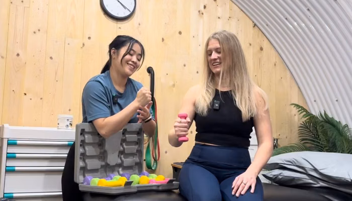 Beth guiding a client through dumbbell rehab work